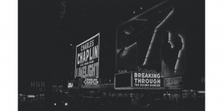Historic photograph of Times Square featuring a cinema marquis with the text: Charles Chaplin Limelight