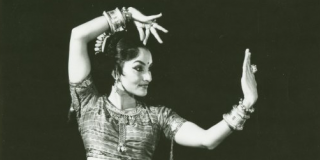 Historic black-and-white photo of a South Asian woman performing a dance