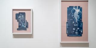 Two blue cyanotypes set on peach backings, depicting small items such as soda tabs and buttons.