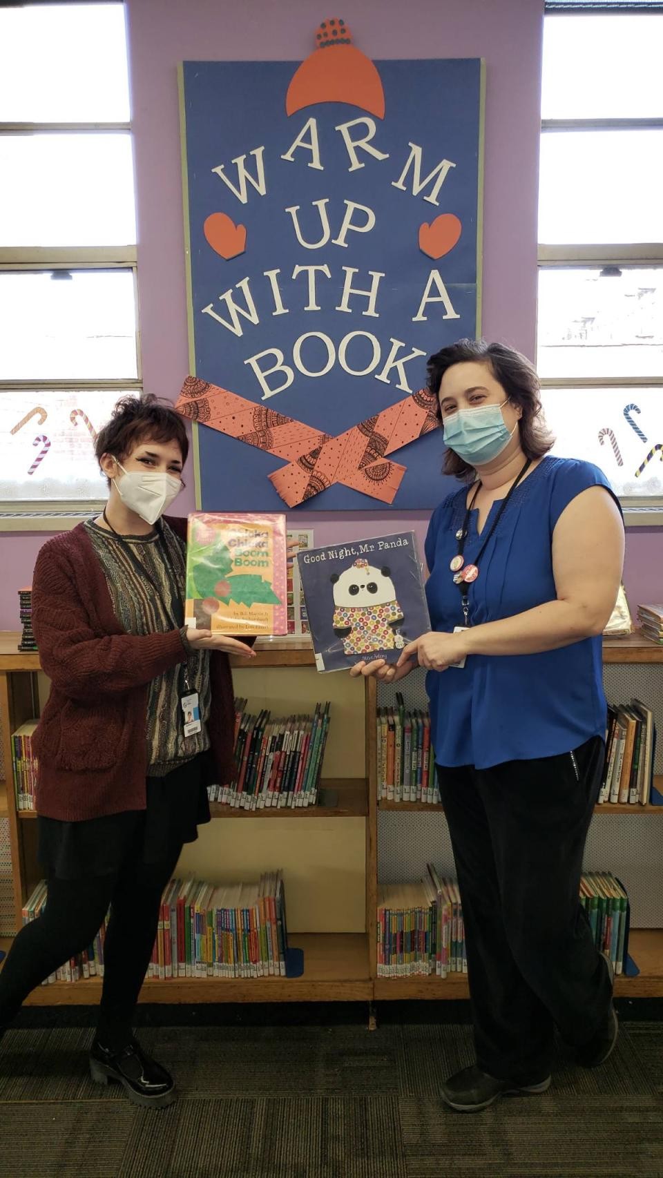 two children's librarians holding picture books
