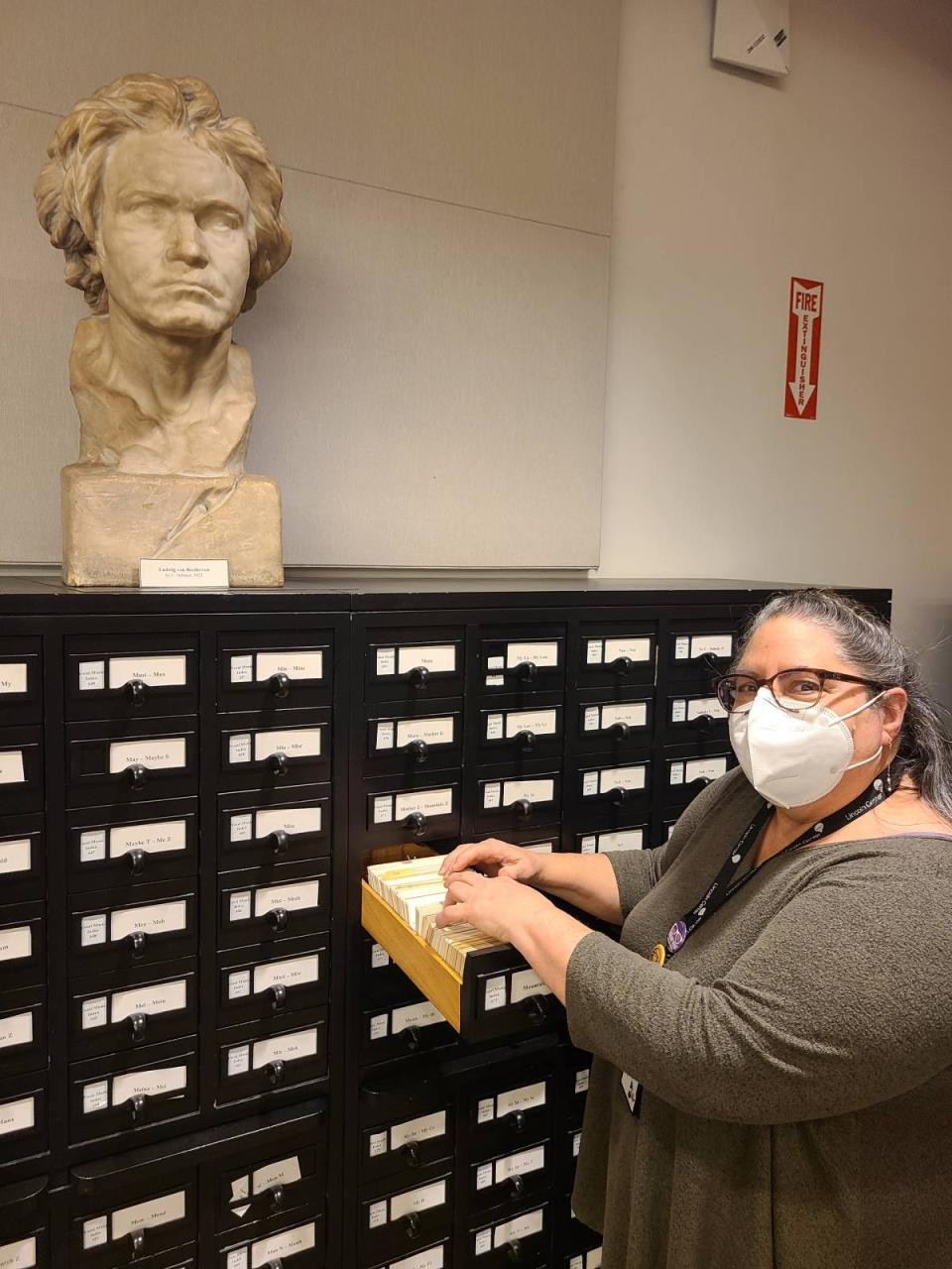 library staff member using a card catalog of vocal music index cards