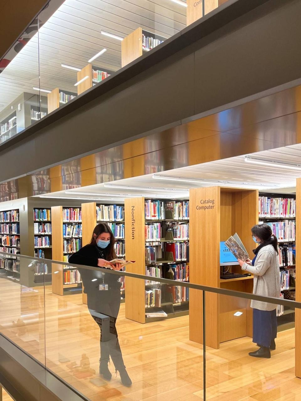 library staff looking at books among shelves of books