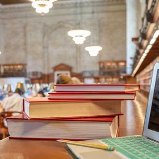 Laptop and stack of books in the Rose Main Reading Room
