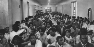 Historic photo taken from high up in a college hallway filled with Black students