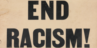 Closeup of a poster with bold, black text that reads: End Racism!
