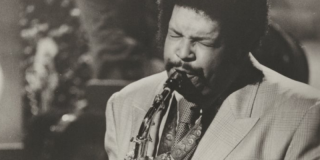 Historic black-and-white photograph of musician Cannonball Adderley playing the alto sax