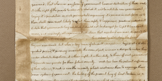 Aged paper document with handwritten script, marks, and creases.