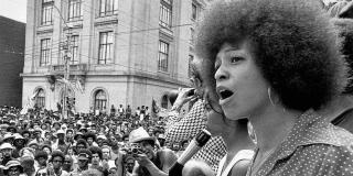 Black and white photograph of Angela Davis in front of a crowd.